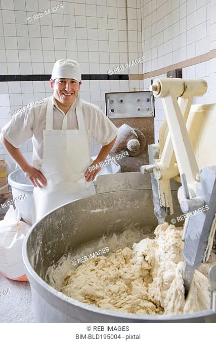 Hispanic baker mixing dough