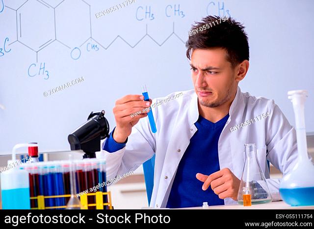 Young chemist sitting in the lab