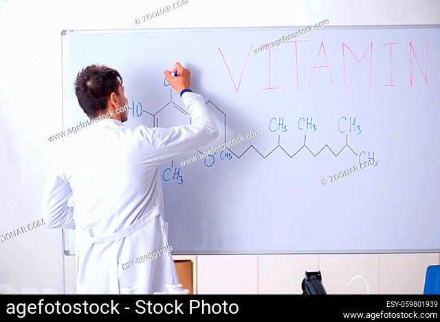 Young chemist standing in front of the whiteboard