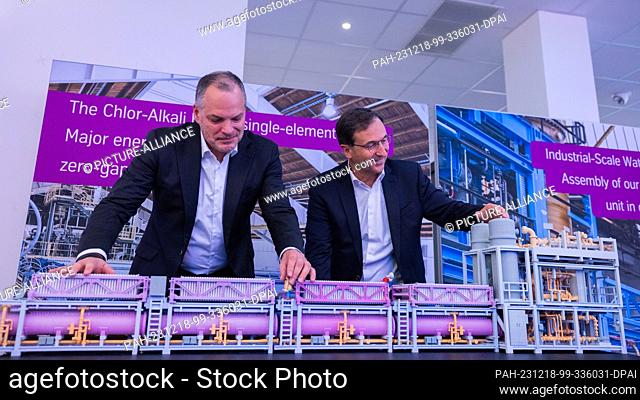 18 December 2023, North Rhine-Westphalia, Dortmund: Werner Ponikwar (l), CEO, and Arno Pfannschmidt, CFO, stand behind a model of an electrolyzer module before...