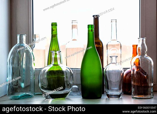various empty bottles on sill of home window on sunny spring day