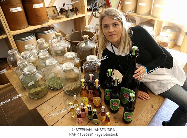 Petra Waldherr-Merk, owner and managing director of the company 'Hirschkuss' (Lit. Stag Kiss) poses for the camera with bottles of liqueur in Gaissach, Germany
