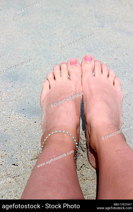 Women's feet in the sand on the beach of Cala Millor, Spain, Balearic Islands, Mallorca, anklets, jewelry