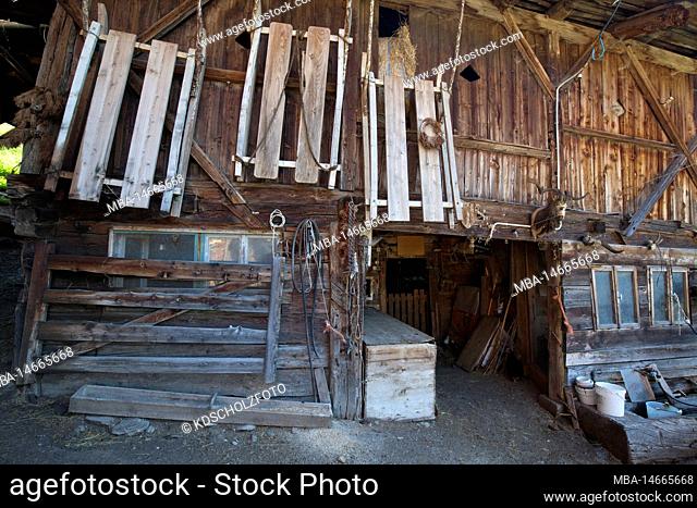 Wooden sledges hanging on the stable from the South Tyrolean farm in the Ulten Valley