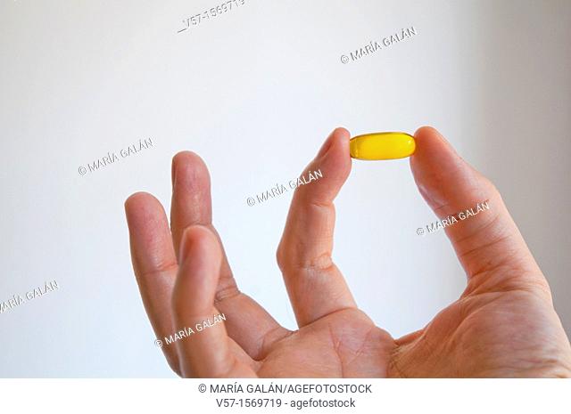 Man's hand holding a primrose pill. Close view