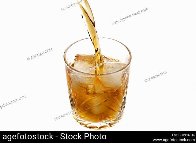 Pouring whiskey in a glass with ice. Top view