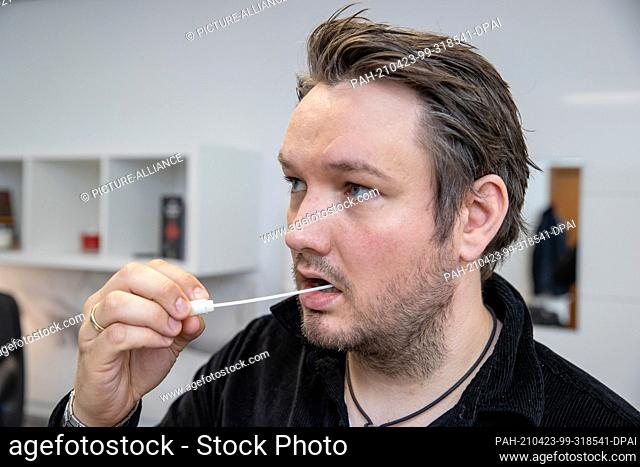 22 April 2021, Bavaria, Nuremberg: Falk Stirkat, medical doctor, takes oral mucosa with a cotton swab from a stem cell donor typing kit