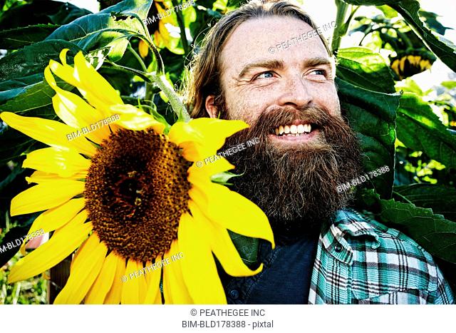 Caucasian man holding sunflower in garden