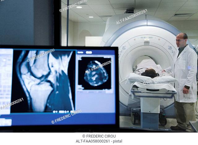 Doctor monitoring patient undergoing MRI scan