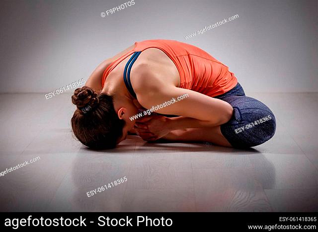 Beautiful sporty fit woman practices yoga asana Baddha konasana - bound angle pose