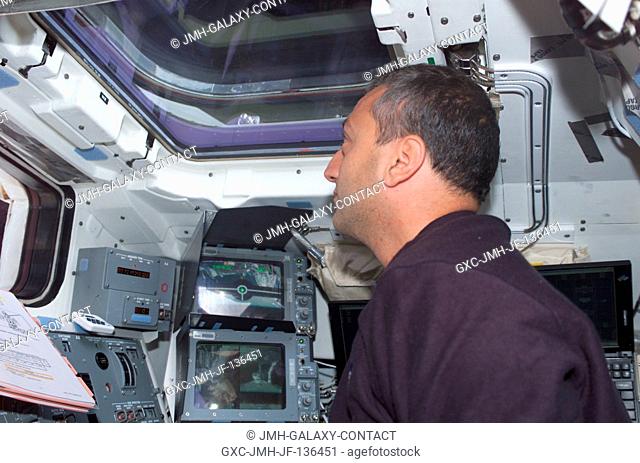 Astronaut Michael J. Massimino, STS-109 mission specialist, looks through an overhead window on the aft flight deck of the Space Shuttle Columbia during the...