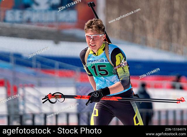 Russian sportsman biathlete Khanzutin Artem skiing on ski track distance biathlon stadium. Junior biathlon competitions East of Cup