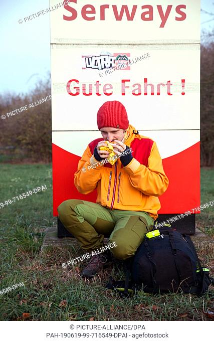 23 November 2018, Saxony-Anhalt, Halle/Saale: On his short trip to the Czech Republic, Malte Stolpe takes a break and eats bread at a rest stop on the A14...