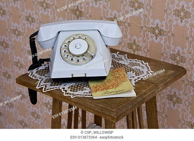 Old rotary phone on table