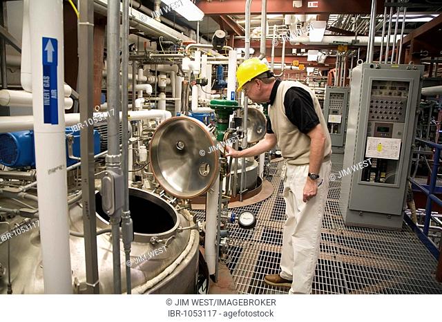 Worker at fermentation tanks for making cellulosic ethanol from non-edible plants at the National Renewable Energy Laboratory