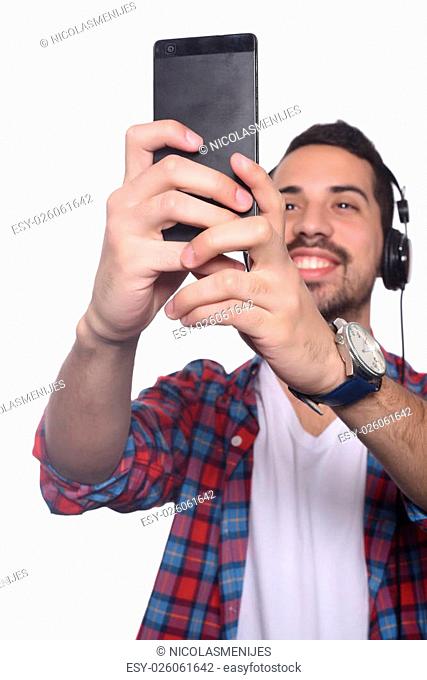Portrait of attractive young man taking a selfie with his smartphone. Isolated white background