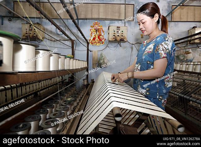 Woman working in a traditional silk factory. Tan Chau. Vietnam