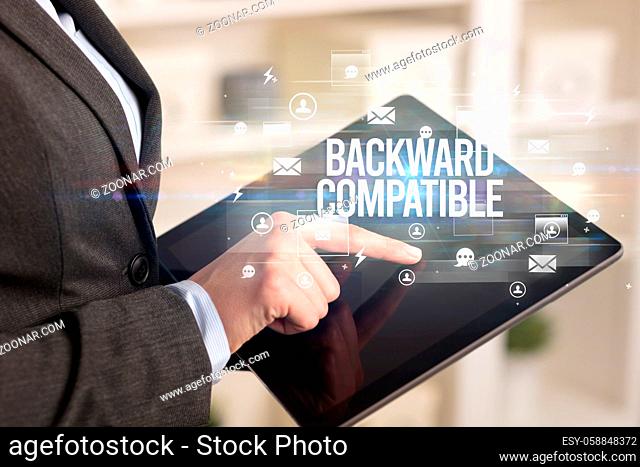 Close-up of a tablet searching BACKWARD COMPATIBLE inscription, modern technology concept
