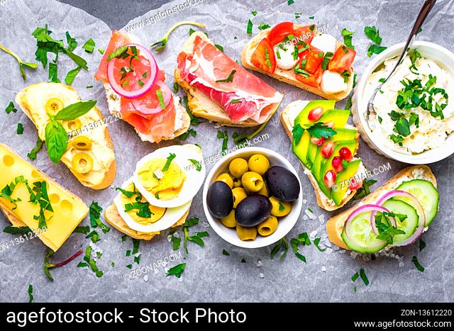 Assorted healthy sandwiches set background. Sandwich bar or buffet. Ciabatta sandwiches with dips, fish, cheese, meat, vegetables. Top view