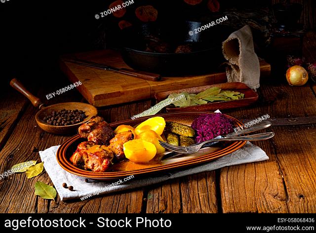 Rustic Snirtjebraten with red cabbage and cucumber