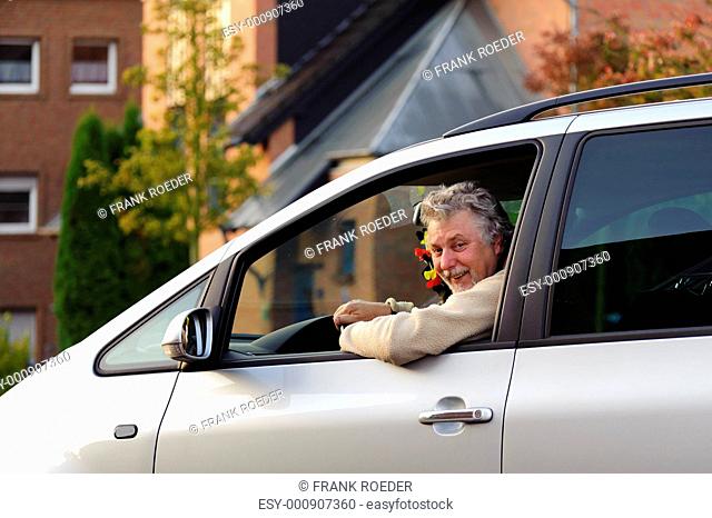 Man sitting in his car and laughing out the window