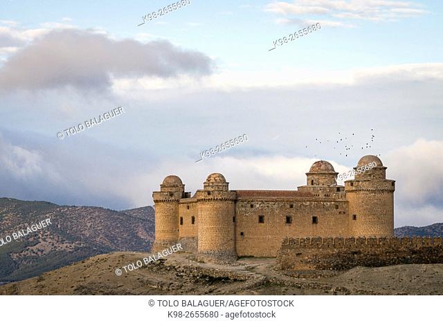 Spain, Andalusia, Granada province, La Calahorra, Flock of birds flying over La Calahorra Castle