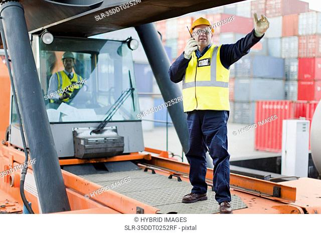 Worker directing machinery on site