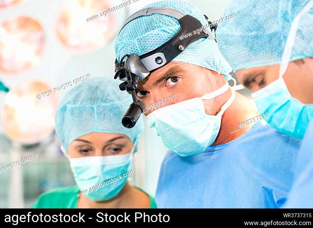 Hospital - surgery team in the operating room or Op of clinic operating on patient in an emergency situation