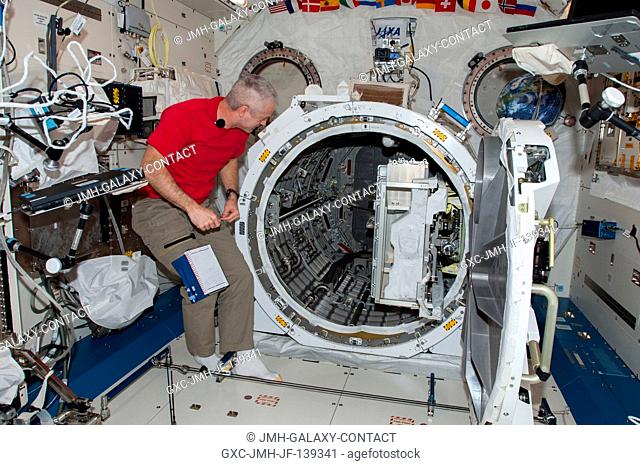 NASA astronaut Steve Swanson, Expedition 40 commander, works with equipment in the airlock in the Kibo laboratory of the International Space Station
