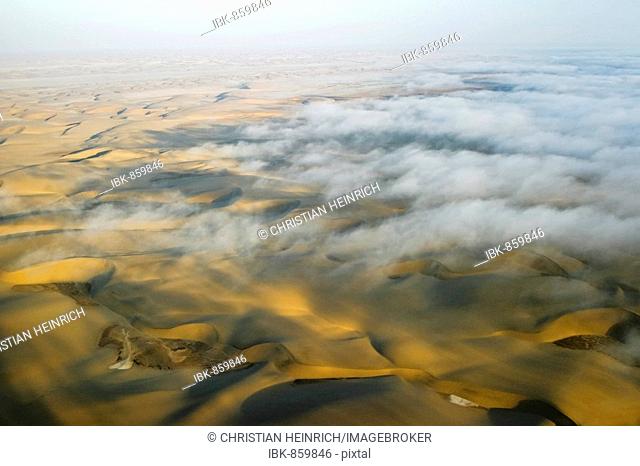 Flight over clouds and sand dunes near the coast in the Namib Desert, Namibia, Africa