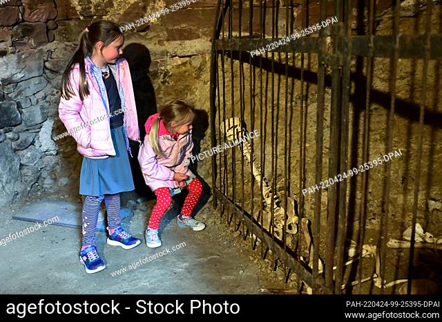 24 April 2022, Hessen, Witzenhausen: Emma (l) and Merle experience the creepy effect in front of the castle skeleton in the dungeon