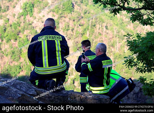 02 June 2020, Saxony-Anhalt, Thale: Firefighters of the fire brigade observe the wildfire at the Roßtrappenfelsen in the Bodetal in Thale