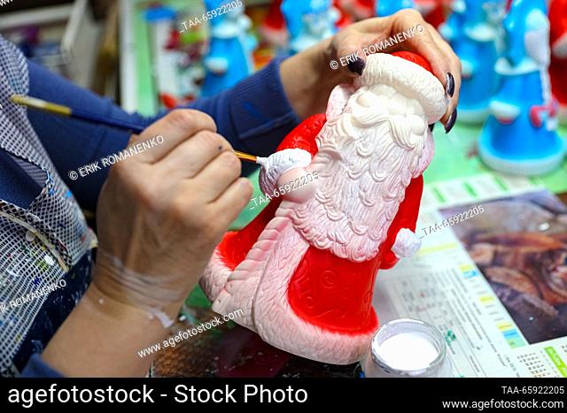 RUSSIA, VORONEZH - DECEMBER 19, 2023: An employee paints a Christmas ornament at the Igrushki toy factory. The enterprise is engaged in production of PVC...