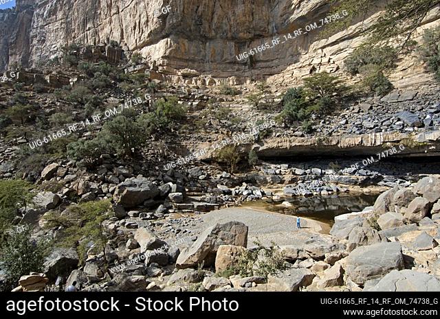 Water pool of the abandoned village of Sap Bani Khamis beneath the rock face of the Grand Canyon of Oman in Wadi an Nakhur, Jabal Akhdar mountains