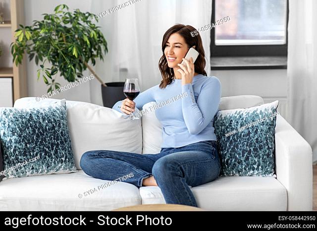 woman calling on smartphone and drinking red wine