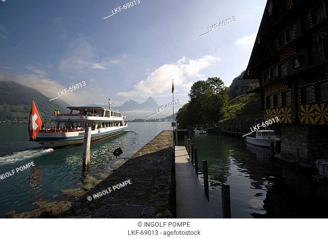 MS Brunnen on Lake Lucerne passing the former shelter harbour Treib with an old tavern, Treib, Canton of Uri, Switzerland