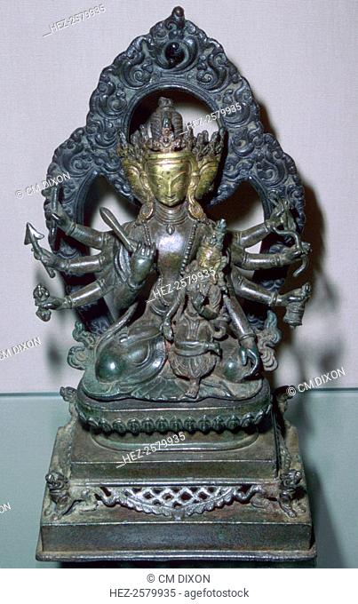 A bronze statuette of Bodhisattva Manjunatha, a Nepalese deity. The god is holding various emblems and weapons in his many arms, including a Vajra (thunderbolt)