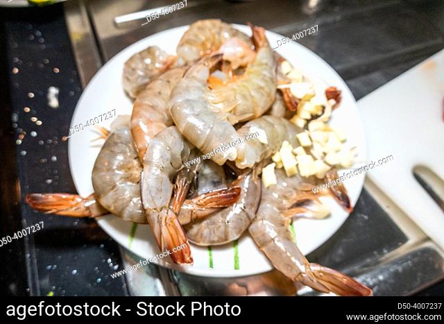 Raw shrimp on a plate getting ready to cook