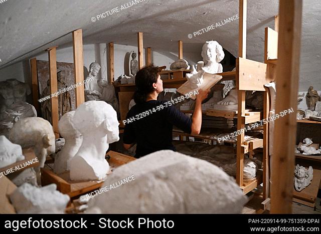 26 July 2022, Bavaria, Garmisch-Partenkirchen: A student at the vocational school for wood sculptors stores a plaster model in the school's plaster basement