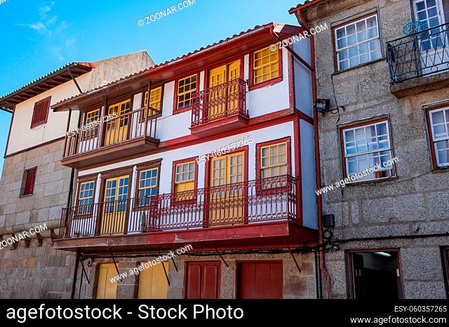 Guimarães, Portugal - Beautiful Preserved Medieval Colorful Traditional Stone Houses with Wood Windows and Small Balconies and Flower Pot