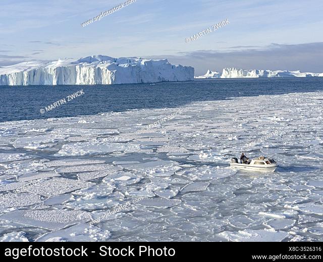 Fisherman fishing in the fjord. Winter at the Ilulissat Icefjord, located in the Disko Bay in West Greenland, the Icefjord is part of the UNESCO world heritage