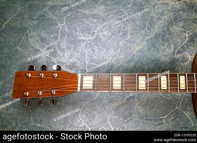 acoustic guitar neck on green marble background, music concept