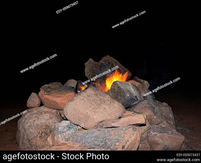 Ein kleines Lagerfeuer in einer Feuerstelle aus Steinen