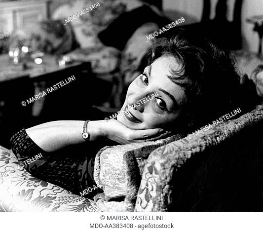 Portrait of Andreina Pagnani smiling at home. Portrait of Italian actress Andreina Pagnani (Andreina Gentili), smiling, sitting in a chair in her house