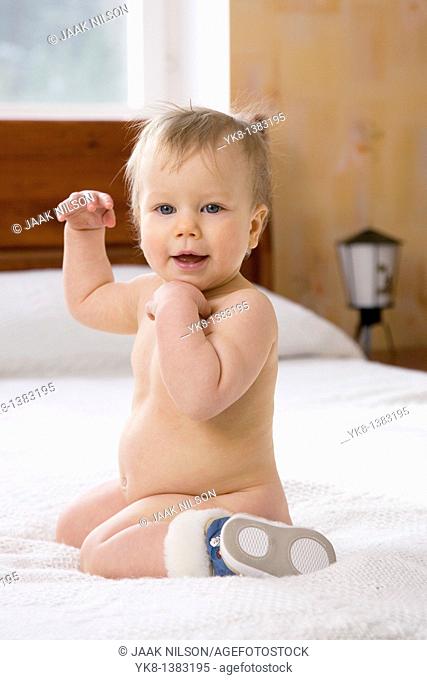 Happy Emotional Naked Ten Month Old Baby Girl Kneel Down on Bed