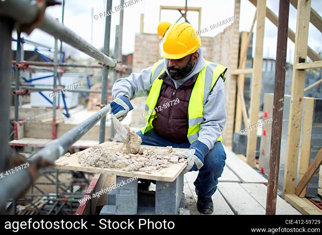 Male construction worker mixing concrete at construction site