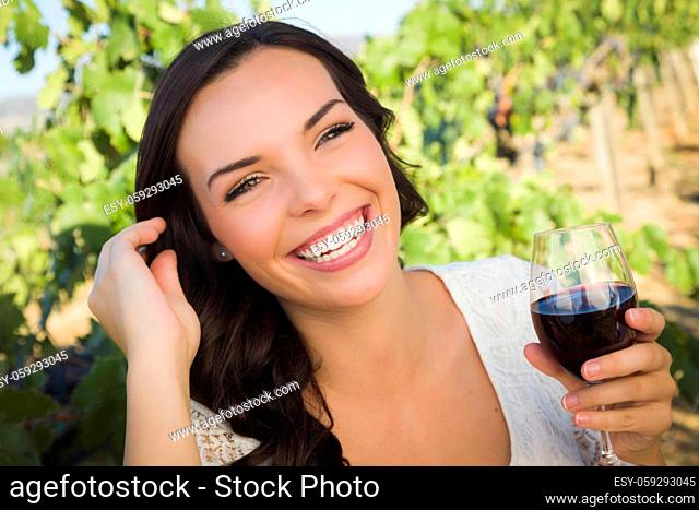 Pretty Mixed Race Young Adult Woman Enjoying A Glass of Wine in the Vineyard