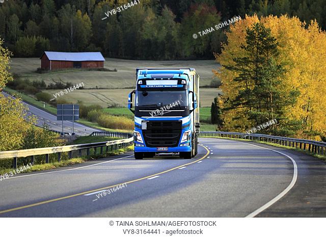 Salo, Finland - October 5, 2018: Blue Volvo FH semi trailer transports goods near sunset time along autumnal highway in South of Finland