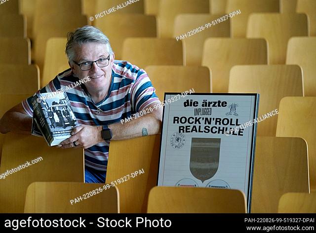 PRODUCTION - 07 July 2022, Hamburg: Janitor André Schulz sits in the auditorium of the Albert Schweitzer High School next to the platinum award for the...