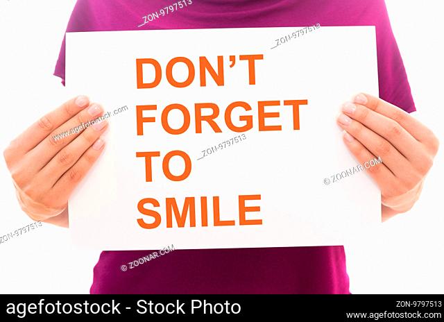 Girl holding white paper sheet with text Don't forget to smile